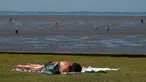 Seorang pria berjemur saat suhu mencapai 34 derajat Celcius di dekat pantai Laut Utara di Wremen, Jerman barat (24/7/2019). Peramal cuaca memprediksi suhu tertinggi di seluruh Eropa barat yang terkena gelombang panas akan mencetak rekor suhu terbaru.  (AFP Photo/Patrik Stollarz)