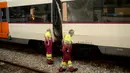 Pekerja melihat kondisi kereta yang rusak di platform sebuah stasiun kereta api di Barcelona, Spanyol, Jumat, (28/7). Puluhan orang terluka saat sebuah kereta komuter pagi yang mereka tumpangi menabrak buffer. (AP Photo/Adrian Quiroga)