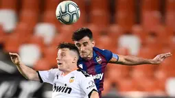 Penyerang Valencia, Kevin Gameiro, berebut bola dengan bek Levante, Sergio Postigo, pada laga pekan ke-28 Liga Spanyol di Stadion Mestalla, Sabtu (13/6/2020) dini hari WIB. Valencia bermain imbang 1-1 atas Levante. (AFP/Jose Jordan)