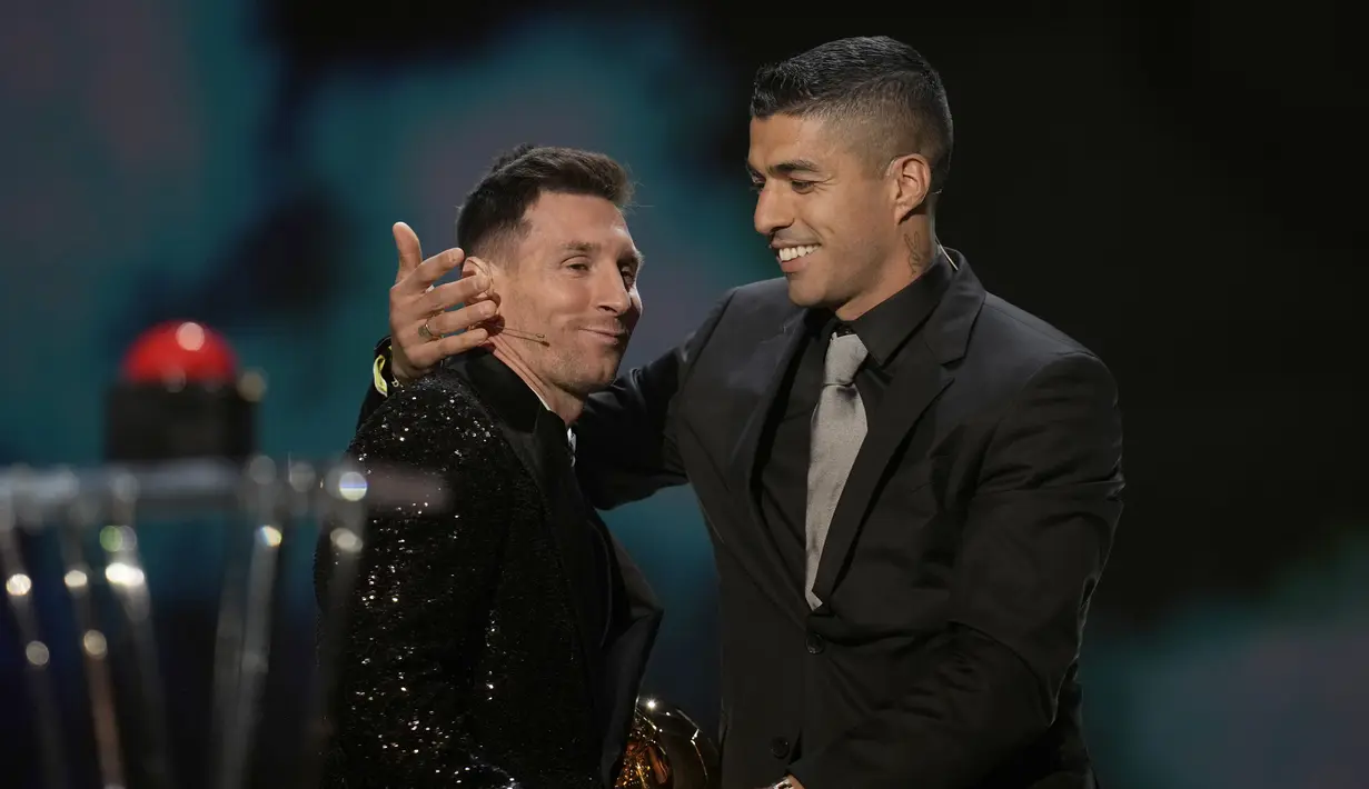 Striker PSG, Lionel Messi menerima trofi Ballon d'Or 2021 dari mantan rekan setimnya di Barcelona Luis Suarez pada acara penganugerahan di Theatre du Chatelet, Paris, Prancis, Senin (29/112021). Lionel Messi menjadi kolektor Ballon d'Or terbanyak dengan total raihan tujuh trofi. (AP Photo/Christophe