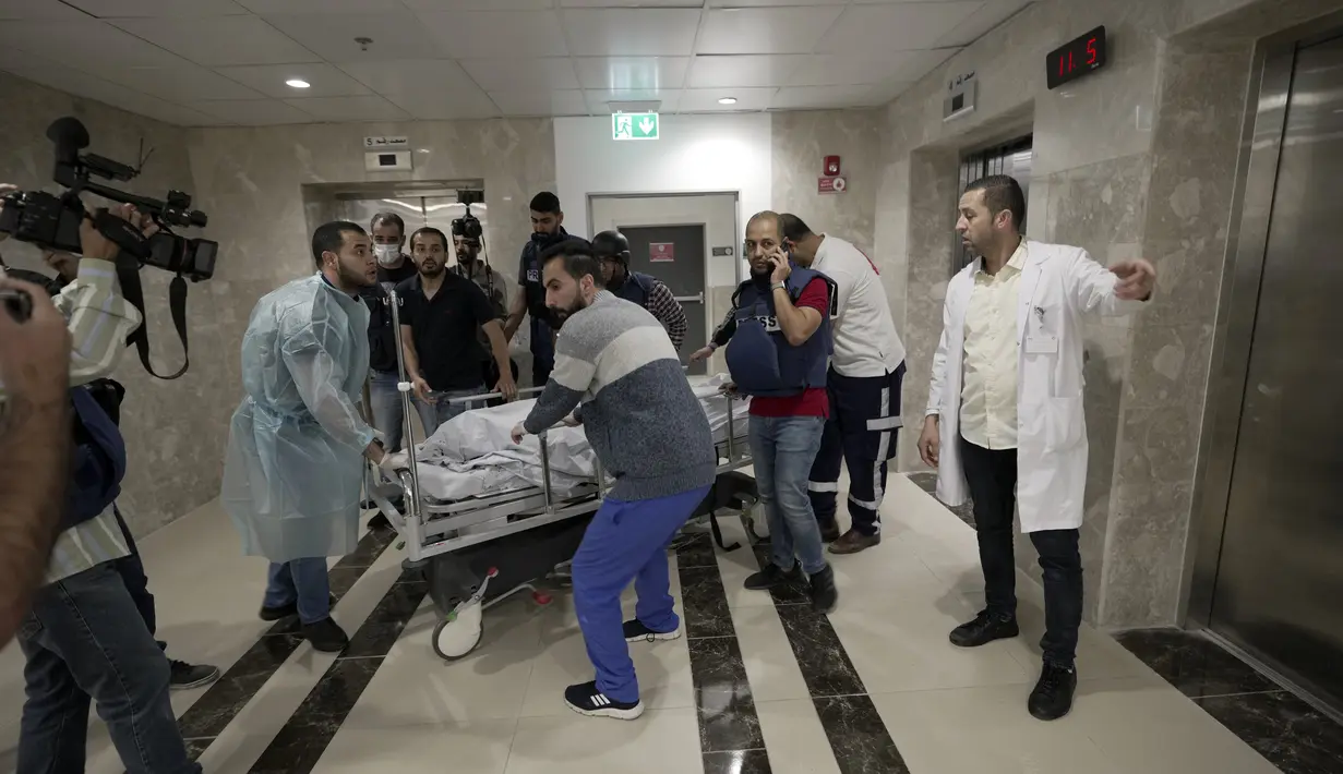 Wartawan dan petugas medis membawa jenazah wartawan Al Jazeera Shireen Abu Akleh ke kamar mayat rumah sakit di Kota Jenin, Tepi Barat, Rabu (11/5/2022). Menurut Kementerian Kesehatan Palestina, Shireen Abu Akleh tewas ditembak saat meliput serangan Israel di Kota Jenin. (AP Photo/Majdi Mohammed)