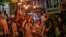 Beberapa anak terlihat antusias mengikuti pawai obor yang dilakukan di salah satu permukiman di kota Surabaya. (Juni KRISWANTO/AFP)