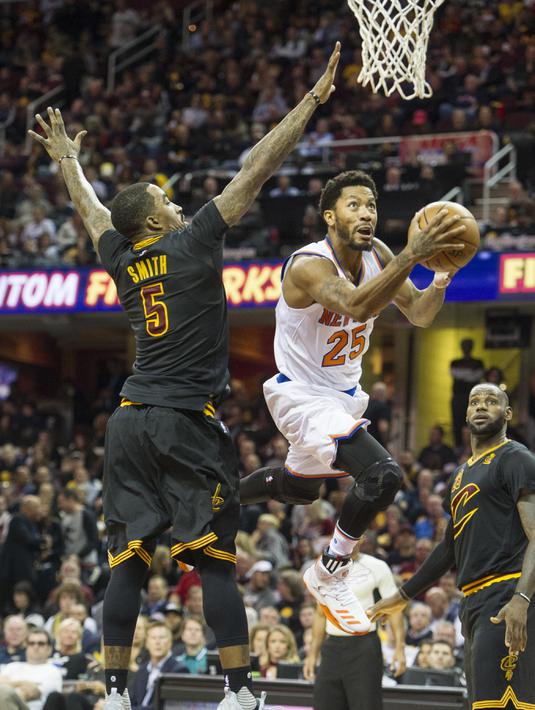 Aksi New York Knicks, Derrick Rose #25 melewati handangan pemain Cleveland Cavaliers,  J.R. Smith #5 pada laga perdana NBA basketball game 2016-2017 di Quicken Loans Arena.  (AP/Phil Long)