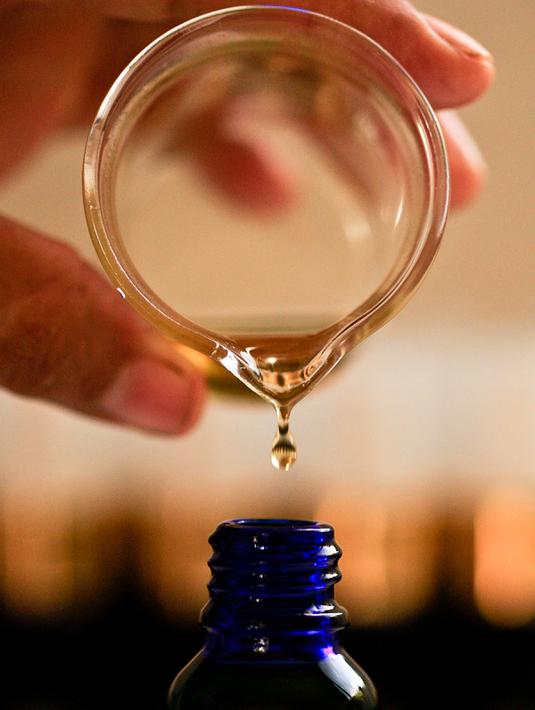 Cairan ekstrak ganja dituangkan dalam kemasan di laboratorium, Toez, Cauca,Kolombia, (13/7). Cara penggunaanya disemprotkan ke bagian intim wanita.(LUIS ROBAYO / AFP)