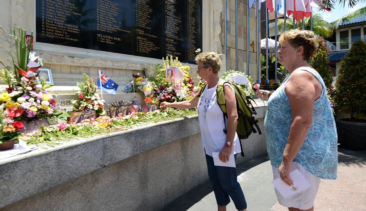 Wisatawan asing menaburkan bunga di Monumen Ground Zero Bali di kawasan Kuta, Bali (12/10). Setiap tanggal 12 Oktober, banyak orang yang datang dari berbagai negara untuk mengenang tragedi bom Bali. (AFP Photo/Sonny Tumbelaka)