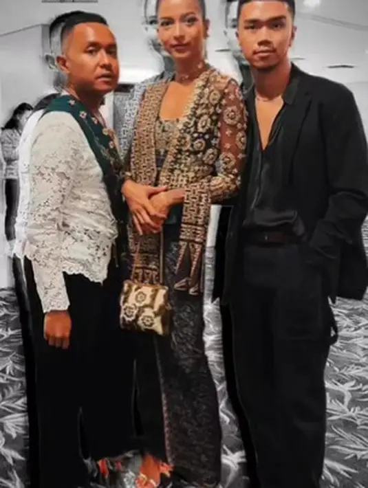Atasan yang menyerupai kebaya kutubaru itu dipadukan dengan kain batik berwarna abu-abu gelap dengan nuansa biru. Serta selendang berwarna cokelat kemerahan di pundak kiri. [instagram/kristo.imanuel]