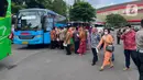 Sejumlah tamu bersiap maniki bus menuju resepsi pernikahan putra bungsu Presiden Jokowi, Kaesang Pangarep dan Erina Gudono di Stadion Manahan, Solo, Jawa Tengah, Minggu (11/12/2022). Bus-bus berukuran tanggung digunakan untuk menjemput para tamu yang turun di Benteng Vastenburg dan Stadion Manahan Solo. (Liputan6.com/Herman Zakharia)