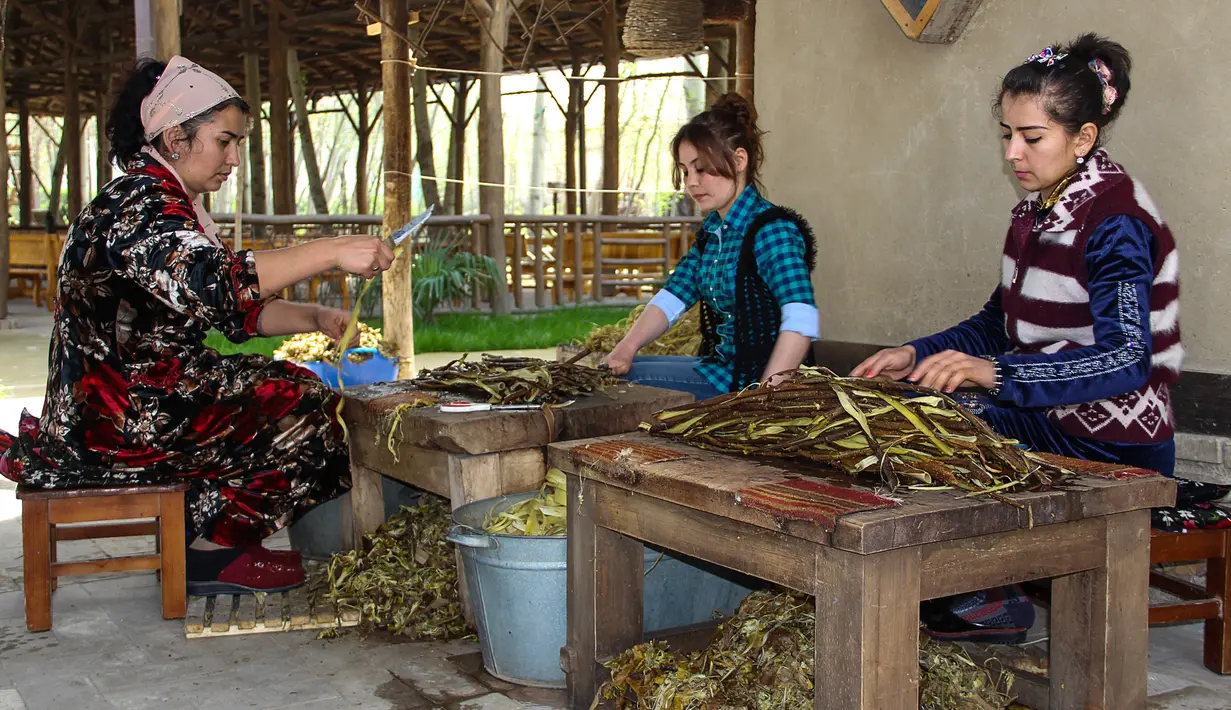 Sejumlah wanita mengolah kulit pohon yang menjadi bahan pembuatan kertas tradisional di pabrik kertas Zarif Mukhtarov di desa Koni Ghil, Uzbekistan (29/3). (STR/AFP)