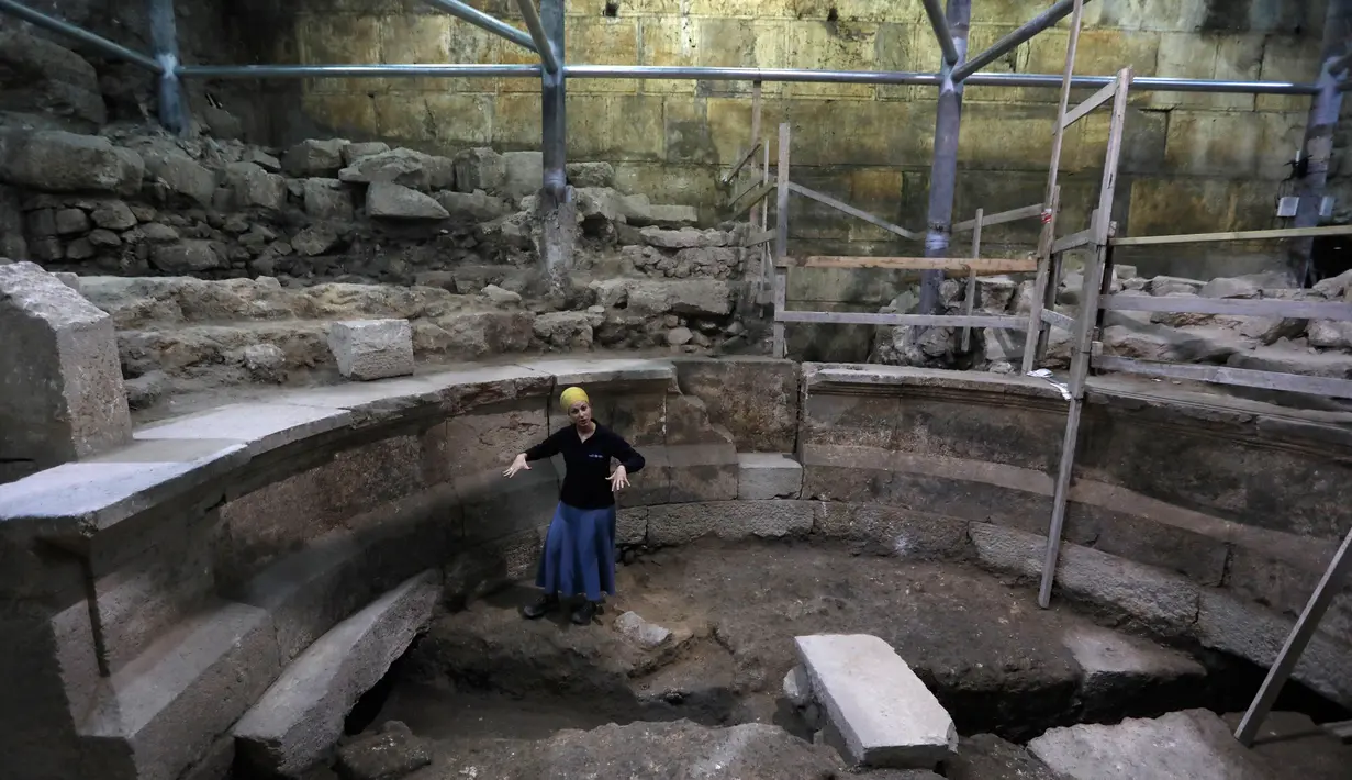 Arkeolog Tehillah Lieberman menunjukkan sebuah teater Romawi kuno yang ditemukan saat penggalian di dekat Tembok Ratapan, sebelah barat Yerusalem, Senin (16/10). Teater itu merupakan bekas era Romawi pertama di Yerusalem. (MENAHEM KAHANA/AFP)