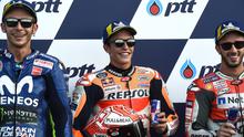 Pebalap Marc Marquez, Valentino Rossi dan Andrea Dovizioso berpose bersama usai mengikuti kualifikasi MotoGP Thailand 2018 di Sirkuit Internasional Buriram (6/10). Rossi berada di posisi kedua dengan catatan waktu 1.30.099. (AFP Photo/Lillian Suwanrmpha)