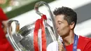 Pemain Bayern Munchen Robert Lewandowski memegang bendera Polandia dan mencium trofi juara Liga Champions usai mengalahkan Paris Saint-Germain di Stadion Luz, Lisbon, 23 Agustus 2020. (Photo by MATTHEW CHILDS/POOL/AFP)