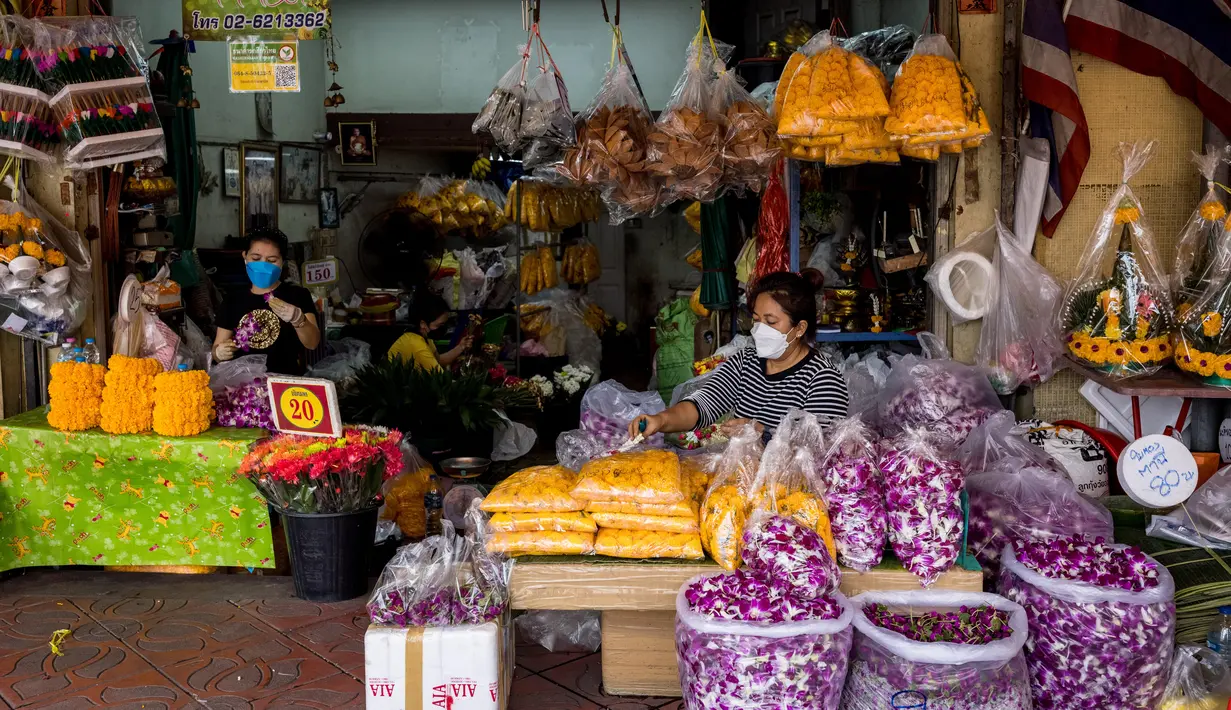 Pedagang menyiapkan bunga menjelang Loy Krathong di pasar bunga Pak Khlong Talat, Bangkok, Kamis (18/11/2021). Bulan November ini Thailand akan mengadakan festival Loy Krathong di mana warga akan menghanyutkan keranjang berisi bunga dan lilin di sungai, kolam atau danau. (Jack TAYLOR/AFP)