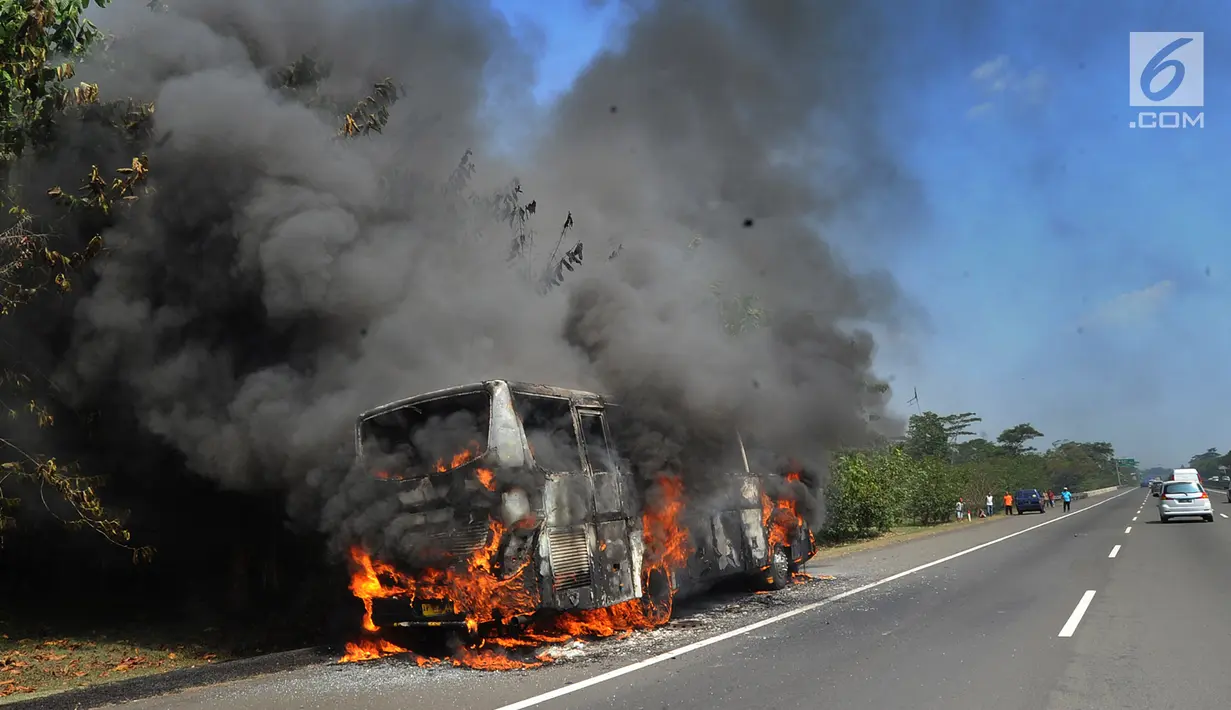 Kobaran api melalap bus pariwisata nopol AB 7536 AK pada ruas tol Jagorawi arah Bogor di KM 36, Bogor, kamis (25/7/2019). Kebakaran bus ini menyebabkan kemacetan lalu lintas menuju Bogor. (merdeka.com/Arie Basuki)