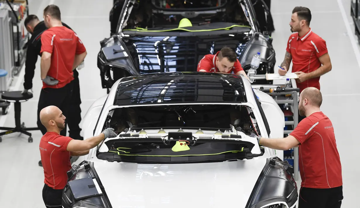 Mekanik memasangkan aksesoris mobil listrik Porsche Taycan saat proses perakitan di pabrik perusahaan Porsche AG di Stuttgart, Jerman, Rabu (4/3/2020). Porsche Taycan merupakan mobil bertenaga listrik pertama  dari pembuat mobil mewah Jerman, Porsche AG. (AFP Photo/Thomas Kienzie)
