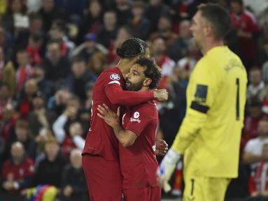 Penyerang Liverpool Mohamed Salah berselebrasi dengan Virgil van Dijk setelah mencetak gol kedua untuk timnya ke gawang Rangers dalam partai matchday 3 fase grup Liga Champions 2022/2023 yang digelar di Anfield, Rabu (5/10/2022) dini hari WIB. Liverpool sukses mengandaskan Rangers dengan skor 2-0. (AP Photo/Rui Vieira)