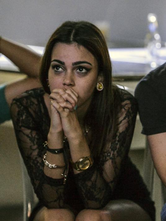 Wajah cemas seorang fans cantik Venezuela saat menyaksikan timnya berlaga melawan Inggris lewat layar TV di Caracas, Venezuela, (11/6/2017). (AFP/Luis Robayo)