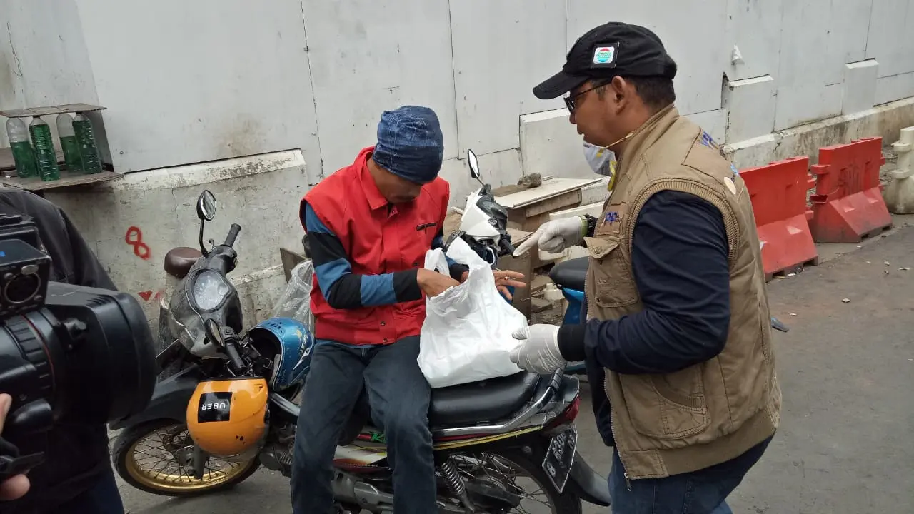 Tim Yayasan Pundi Amal Peduli Kasih (YPP) dan Bukalapak membagikan paket makan siang dan hand sanitizer kepada warga masyarakat.