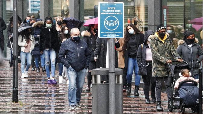 Orang-orang mengantre di depan sebuah toko di pusat Kota Essen, Jerman, Senin (14/12/2020). Jerman melakukan lockdown nasional pada 16 Desember 2020 untuk memerangi pandemi COVID-19. (AP Photo/Martin Meissner)