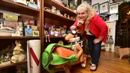 Pendiri Bunny Museum, Candace Frazee berdiri disamping koleksi benda-benda kelinci di Pasadena, California, 8 Desember 2016. Ada puluhan ribu koleksi dan ada pula kelinci hidup yang bebas bermain dengan pengunjung di area museum. (Frederic J. BROWN/AFP)