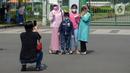 Warga berfoto di depan pagar Monumen Nasional (Monas), Jakarta, Sabtu (15/5/2021). Warga kecewa lantaran tempat wisata tersebut ditutup, padahal mereka datang untuk menikmati libur Idul Fitri 1442 Hijriah. (merdeka.com/Imam Buhori)