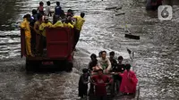 Warga melintasi banjir yang merendam kawasan Green Garden, Jakarta Barat, Selasa (25/2/2020). Hujan yang mengguyur kawasan Jakarta membuat kawasan tersebut tergenang banjir setinggi 60-80 cm. (Liputan6.com/Johan Tallo)