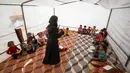 Seorang guru menerangkan pelajaran kepada anak-anak Suriah yang terlantar di dalam tenda yang diubah menjadi ruang kelas di kamp pengungsi di kota Maarrat Misrin di Provinsi Idlib, Suriah (6/10/2020). (AFP/Omar Haj Kadour)