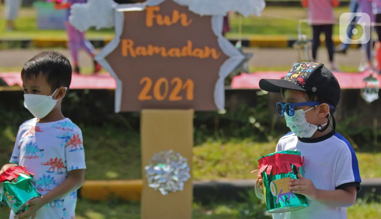 Para siswa TK membawa miniatur bedug saat mengikuti proses pembelajaran secara Drive in Learning di area parkir Padepokan Pencak Silat Indonesia, Jakarta, Kamis (8/4/2021). Kegiatan ini juga untuk menyambut Ramadan dengan penuh rasa syukur dan kebahagiaan. (Liputan6.com/Herman Zakharia)