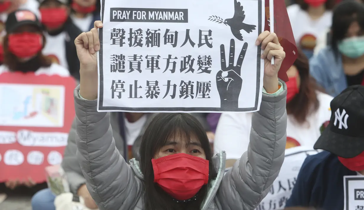 Seorang warga negara Myanmar yang tinggal di Taiwan memegang poster bertuliskan "Mendukung Rakyat Myanmar. Mengutuk Kudeta Militer. Hentikan Penindasan dengan Kekerasan” selama aksi demonstrasi di Liberty Square di Taipei, pada Minggu (21/3/2021). (AP/Chiang Ying-ying)