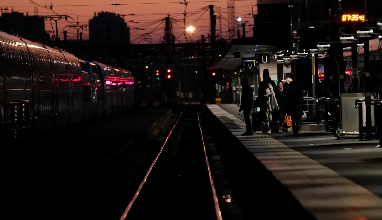 Calon penumpang menanti kedatangan kereta di stasiun Gare de Lyon Paris, Prancis, Selasa (7/2/2023). Parlemen Prancis telah mulai membahas dan memperdebatkan proposal reformasi pensiun yang tidak populer dari Presiden Emmanuel Macron terkait penundaan usia pensiun yang memicu pemogokan dan demonstrasi besar-besaran dalam beberapa pekan terakhir. (AP Photo/Christophe Ena)