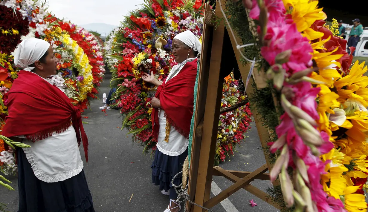 Warga berdiri diantara rangkaian bunga saat digelarnya festival bunga tahunan di Medellin, Kolombia, Minggu (9/8/2015). Festival yang dikenal dengan nama Silleteros Parade ini telah dilangsungkan sejak 1957. (REUTERS/Fredy Builes)