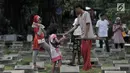 Sejumlah anak saat membagi hasil dari jasa 'Ngoret' makam di TPU Cipinang Baru, Jakarta, Minggu (5/5). Tradisi ziarah makam atau nyekar membawa berkah rezeki bagi anak-anak yang menawarkan jasa Ngoret. (merdeka.com/Iqbal S. Nugroho)