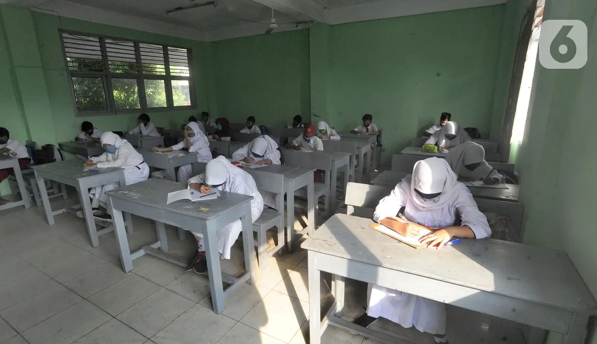 Murid baru menggunakan masker  mengikuti tes penentuan kelas tahun ajaran 2020-2021 yang selanjutnya akan mengikuti kegiatan belajar mengajar (KBM) secara darling di MTs Hidayatul Umami, Cinere, Depok, Jawa Barat, Senin (13/7/2020). (merdeka.com/Arie Basuk)