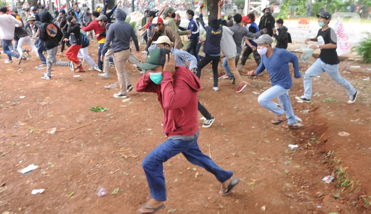 Sejumlah pengunjuk rasa melemparkan batu di Jalan MH Thamrin, Jakarta, Selas (13/10/2020). Massa pengunjuk rasa yang menolak Omnibus Law akhirnya dibubarkan dengan tembakan gas air mata. (merdeka.com/Arie Basuki)