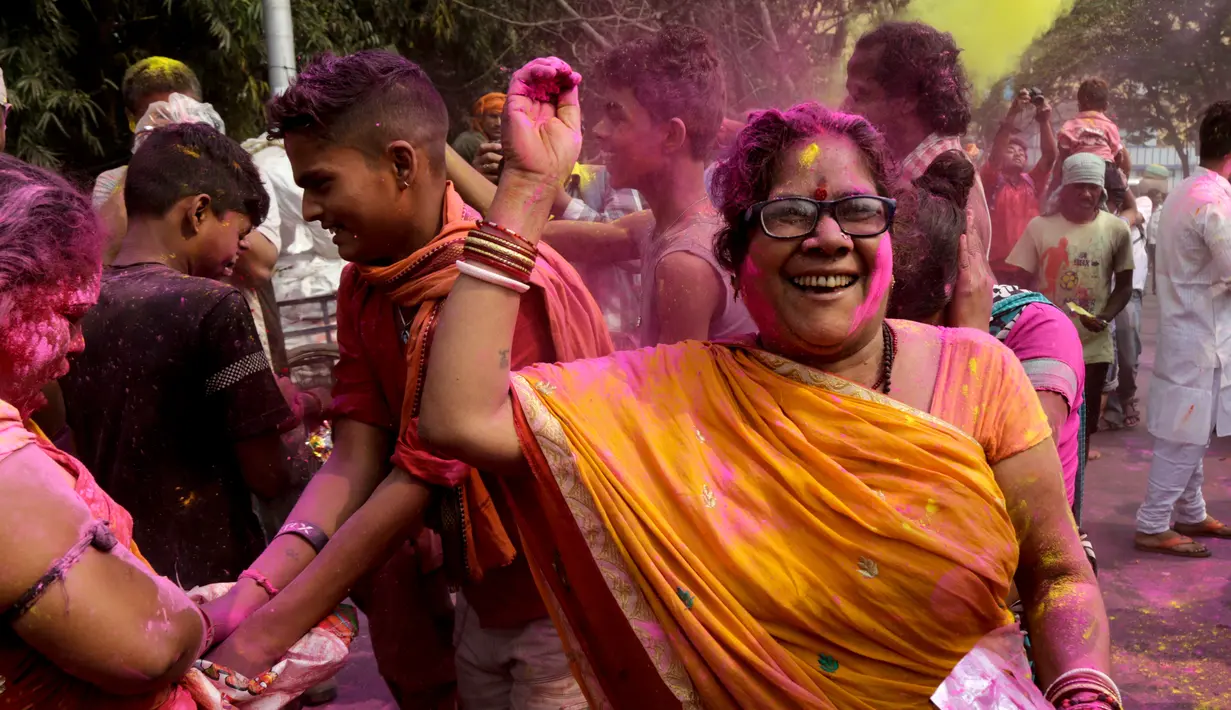 Seorang wanita melemparkan tepung berwarna-warni ke orang lain saat merayakan Festival Holi di Kolkata, India, Rabu (28/2). Festival ini juga mendatangi datangnya musim semi. (AP Photo/Bikas Das)