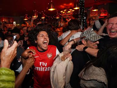 Suka cita menyelimuti para suporter Arsenal setelah The Gunners memastikan diri sebagai juara Liga Inggris musim 2025/2026. (AP Photo/Alberto Pezzali)