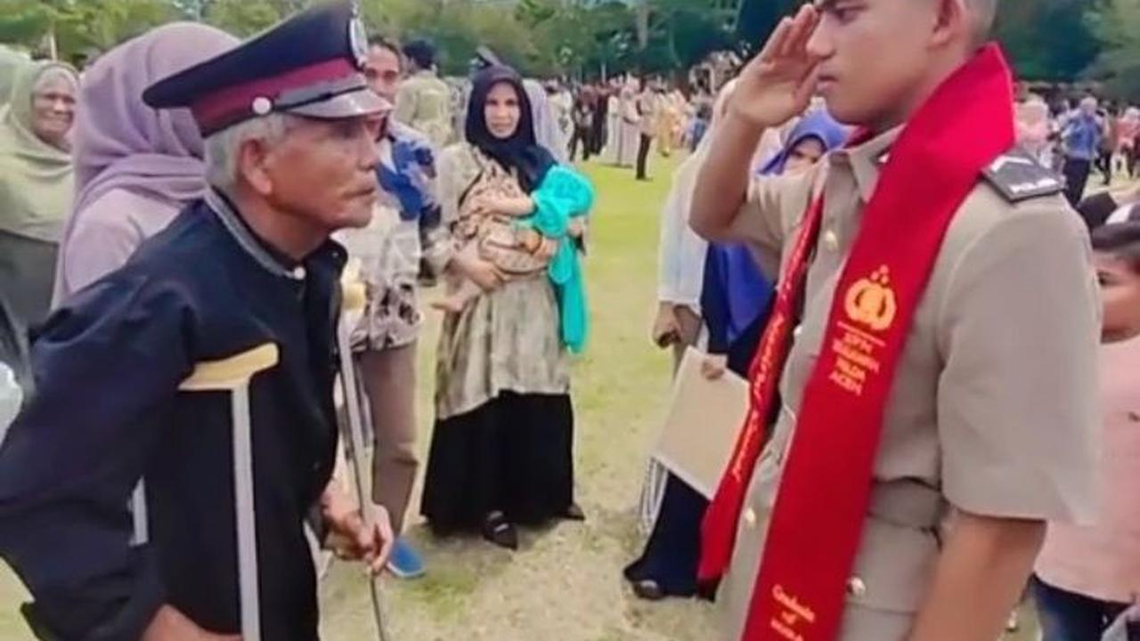 Ia kemudian memakaikan atribut yang dipake pada sang ayah dan mengambil sikap hormat pada ayahnya.