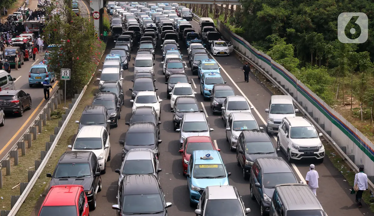 Sejumlah kendaraan terjebak kemacetan panjang di tol yang mengarah ke Bandara Soekarno-Hatta (Soetta), Tangerang, Banten, Selasa (10/11/2020). Kemacetan terjadi karena adanya penyambutan kepulangan pimipinan Front Pembela Islam (FPI) Rizieq Shihab. (Liputan6.com/Angga Yuniar)