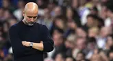 Pelatih Manchester City, Pep Guardiola tak mampu menutupi rasa kecewa setelah timnya kalah dari Real Madrid dalam laga leg 2 play off Liga Champions 2024/2025 di Santiago Bernabeu, Madrid, Spanyol, Rabu (20/02/2025) waktu setempat. (AP Photo/Manu Fernandez)
