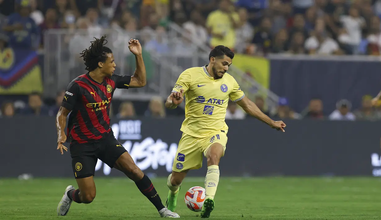 Bek Manchester City, Nathan Ake berebut bola dengan pemain Club America, Henry Martin selama pertandingan persahabatan Pra-Musim di NRG Stadium di Houston, Texas (20/7/2022). City menang tipis atas America 2-1. (AFP/ ARON M. SPRECHER)