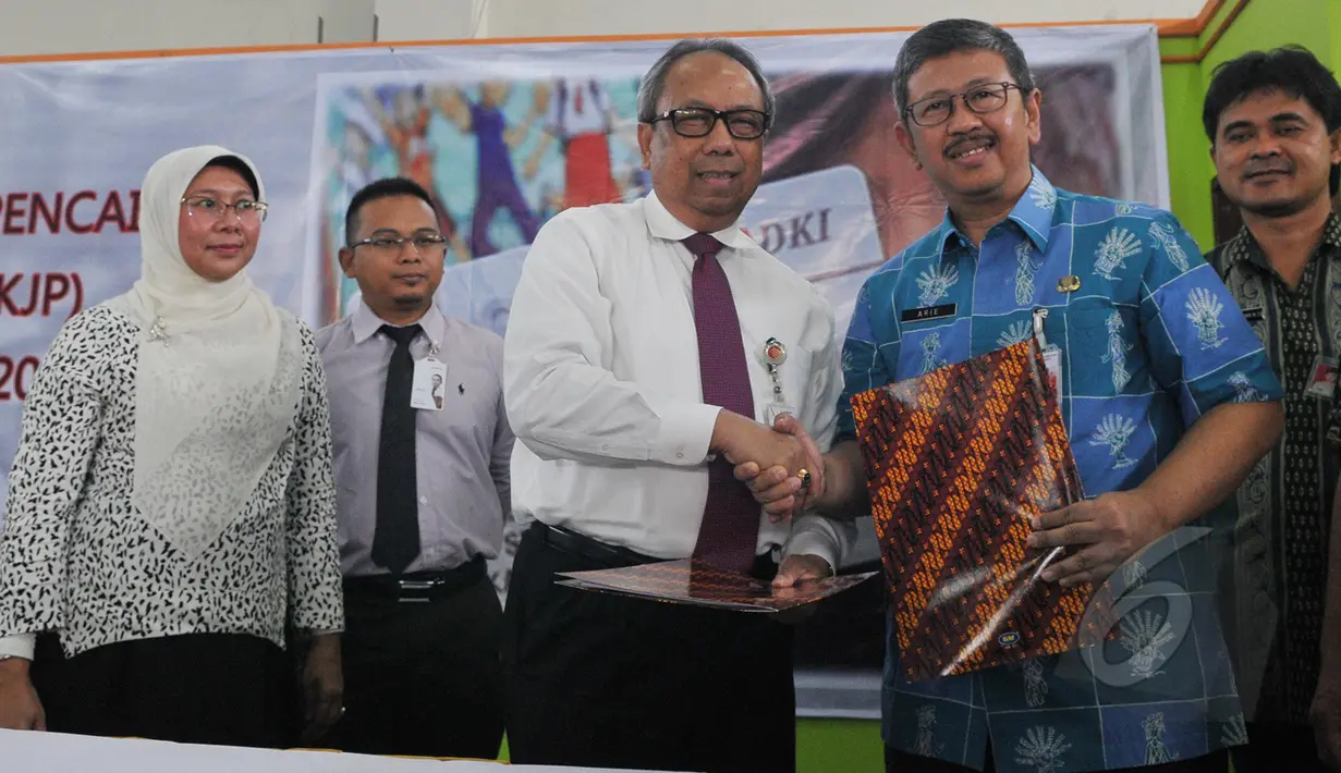 Kepala Dinas Pendidikan Arie Budhiman (kedua kanan) dan Dirut Bank DKI,  Eko Budiwiyono  bersalaman usai Sosialisasi pencairan dana KJP di SMKN 56 Pluit, Jakarta, Kamis (21/5/2015). (Liputan6.com/Herman Zakharia)