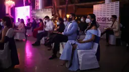 Penonton yang mengenakan masker menyaksikan kontes Miss Nikaragua 2020 di tengah pandemi Covid-9 di Managua, 8 Agustus 2020. Acara tersebut berlangsung dengan tetap menerapkan protokol jarak sosial itu dihadiri 85 orang dari kru produksi. (AP Photo/Alfredo Zuniga)