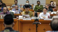 Dirjen Penyelenggaraan Haji dan Umrah (PHU) Hilman Latief (kanan) dan Kepala Badan Pengelola Keuangan Haji (BPKH) Fadlul Imansyah (tengah) menyampaikan paparan saat rapat dengar pendapat bersama Komisi VIII DPR di Kompleks Parlemen, Senayan, Jakarta, Selasa (14/2/2023). Pengumuman terkait besaran biaya haji terpaksa ditunda hingga besok lantaran pemerintah bersama Panja Komisi VIII DPR masih belum menemui kesepakatan. (Liputan6.com/Faizal Fanani)