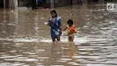 Warga berjalan melintasi banjir di Jalan Jatinegara Barat, Jakarta Timur, Selasa (6/2). Deras dan tingginya debit air di Kali Ciliwung membuat Jalan Jatinegara Barat terputus. (Liputan6.com/Arya Manggala)