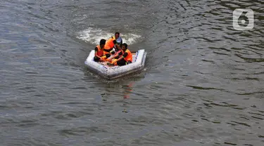 Petugas UPK Badan Air Provinsi DKI Jakarta melakukan ujicoba ketahanan dan kesimbangan perahu yang terbuat dari botol plastik bekas di aliran Kanal Banjir Timur (KBT), Jakarta, Selasa (5/3/2024). (merdeka.com/Imam Buhori)