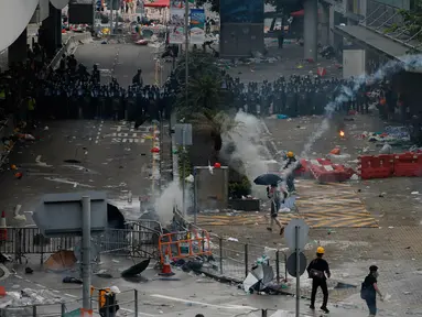 Polisi anti huru hara menembakkan gas air mata ke arah demonstran di luar gedung Dewan Legislatif, Hong Kong, Rabu (12/6/2019). Polisi Hong Kong telah menggunakan gas air mata ke arah ribuan demonstran yang menentang RUU ekstradisi yang sangat kontroversial. (AP Photo/Vincent Yu)