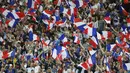 Suporter Prancis mengibarkan bendera saat timnya bertanding melawan Inggris pada laga persahabatan di Stade de France, Saint Denis, Paris, (13/6/2017).  Prancis menang 3-2. (AP/Francois Mori)