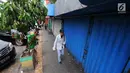 Pejalan kaki melintas di depan pertokoan yang tutup di Jalan Sabang, Jakarta pada Rabu (22/5/2019). Pemilik toko dan pengelola kantor di kawasan tersebut menutup toko dan kantor mereka imbas aksi 22 Mei 2019 yang berakhir rusuh di beberapa titik lokasi. (Liputan6.com/Aangga Yuniar)