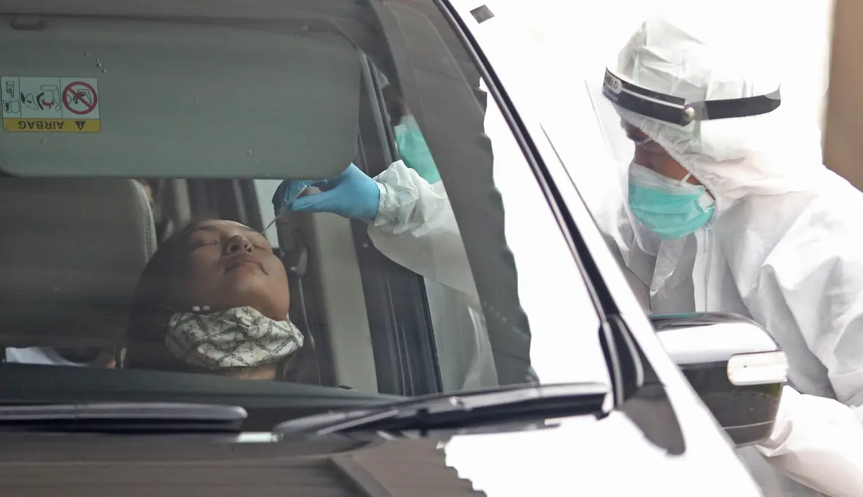 Tenaga kesehatan menggunakan alat pelindung diri (APD) melakukan tes swab di GSI Lab (Genomik Solidaritas Indonesia Laboratorium), Jakarta, Sabtu (3/10/2020). Pemerintah telah menyepakati batas maksimal harga tes usap atau swab mandiri sebesar Rp900 ribu. (Liputan6.com/Herman Zakharia)