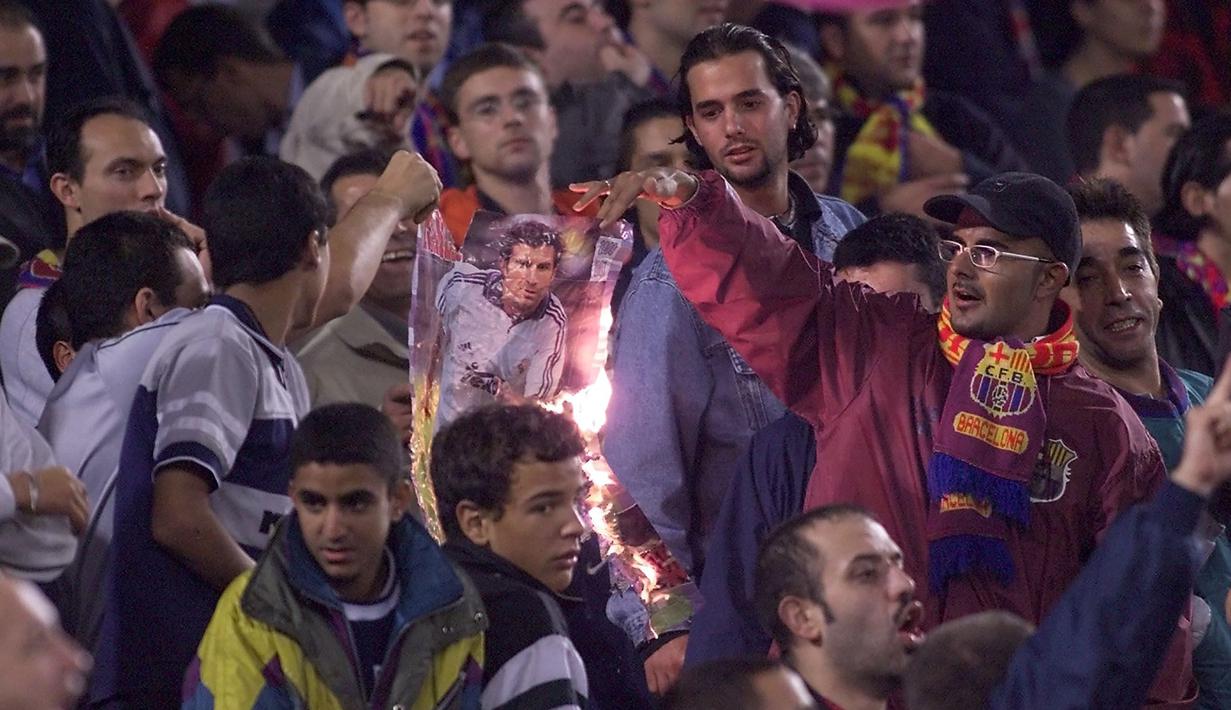 Kala Real Madrid bertandang ke markas Barcelona saat El Clasico musim 2002/2003. Beberapa kelompok suporter Barcelona membakar poster Figo dan melakukan aksi pelemparan ke dalam stadion ketika Figo hendak melakukan sepak pojok. (AFP/Christophe Simon)
