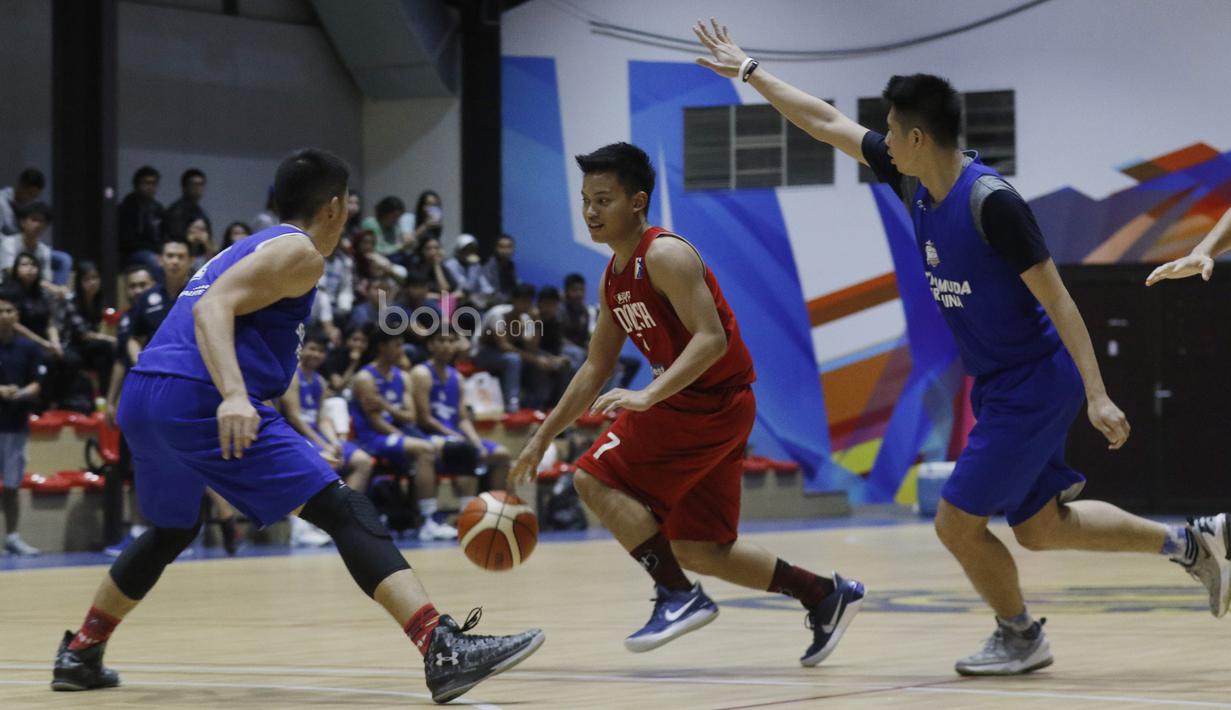 Pemain Timnas Basket Indonesia, Andakara Prastawa, berusaha melewati pemain Satria Muda saat laga uji coba di BSD, Tangerang, Jumat (21/7/2017). Timnas Basket menang 87-52 atas Satria Muda. (Bola.com/M Iqbal Ichsan)